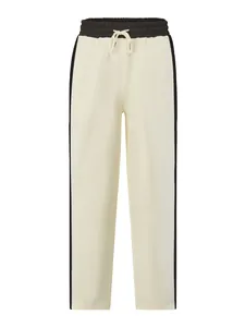 Front view of cream-colored sweatpants featuring black side stripes and drawstring waist