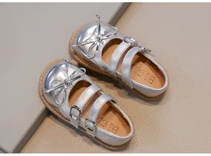 Detail showing silver shiny Mary Jane shoes for girls with elegant bow and double straps