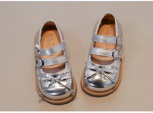 Detail of girls' silver metallic Mary Jane princess shoes with double straps and bows