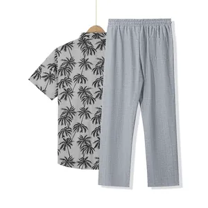 Vista detallada del conjunto de dos piezas con camisa de palmeras y pantalón gris para hombre.