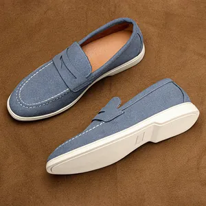 Detailed macro view of men's blue textured slip-on loafers with white rubber soles