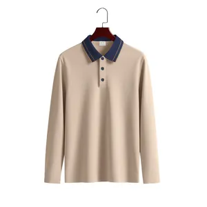 Tan long-sleeved pique polo shirt with navy contrast collar displayed on a hanger