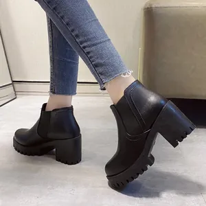 Zijaanzicht van zwarte Chelsea boots met blokhak en dikke profielzool aan het model
