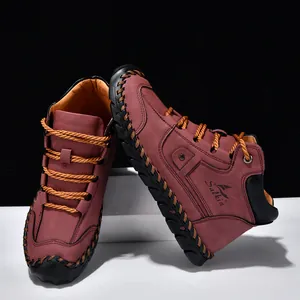 Detail of men's leather ankle boots with hand-stitched seams and orange laces