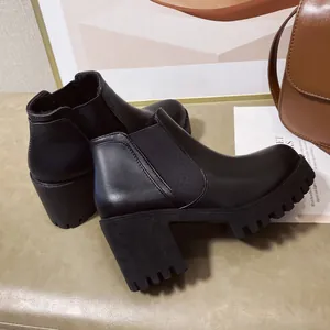 Gedetailleerd zijaanzicht van zwarte Chelsea boots voor dames met blokhak en een stoere profielzool