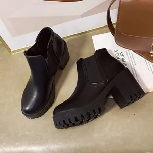 Detailweergave van zwarte Chelsea boots met blokhak, grove zool en een ronde neus