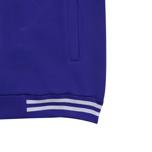 Détail de l'ourlet côtelé avec deux rayures blanches sur un blouson teddy bleu roi