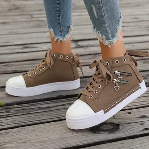 Detailed view of women's brown high-top canvas shoes with side heart zippers