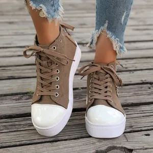 Close-up of brown canvas high-top sneakers with white rubber toe and thick platform sole