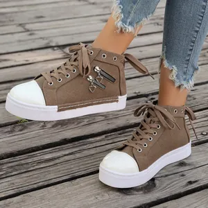 Detailed view of women's brown high-top canvas sneakers with heart charms on wooden deck