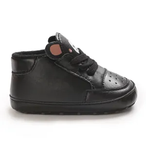 Vue latérale de jolies chaussures pour bébé en similicuir noir avec oreilles d'ours