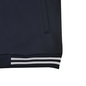 Détail d'un blouson d'université bleu marine avec un ourlet côtelé à rayures blanches