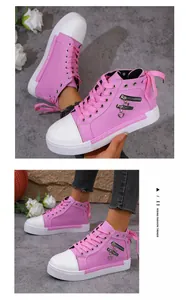 Detail shot of pink high-top canvas sneakers with heart charms and side zippers.