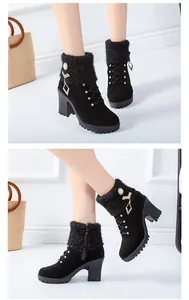 Detail of black suede-like ankle boots with fuzzy cuffs and rhinestone charms.
