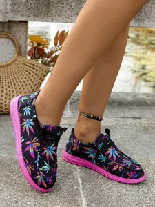 Close-up of colorful leaf print canvas loafers for women with bright pink soles
