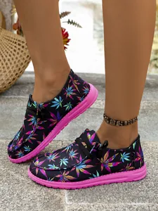 Detailed close-up of colorful leaf pattern canvas loafers with vibrant pink rubber soles