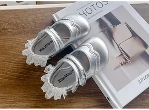 Vue détaillée des chaussures argentées pour bébés filles avec dentelle élégante