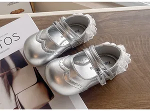 Détail de chaussures de princesse argentées pour bébé avec bordure en dentelle élégante.