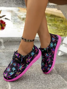Macro view of women's casual canvas shoes featuring colorful leaf print and pink soles