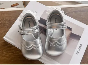 Détail de chaussures de princesse argentées pour tout-petit avec bordure en dentelle.