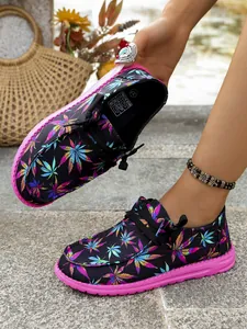 Detailed view of colorful leaf print canvas loafers featuring vibrant pink rubber soles.