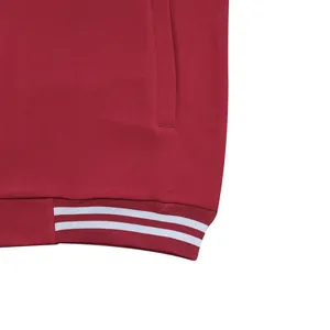 Gros plan sur l'ourlet rayé d'une veste de baseball bordeaux pour homme