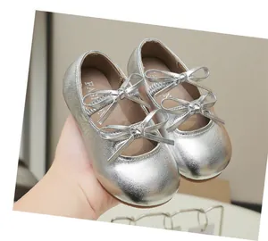 Close-up of silver metallic girls' Mary Jane shoes with elegant bow knot accents
