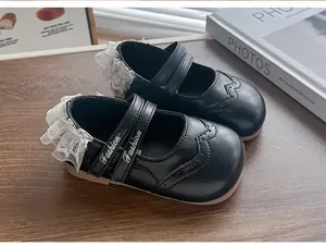 Vue détaillée de chaussures de princesse noires avec volants en dentelle blanche et motifs brogues