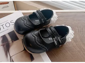 Vue détaillée de chaussures de princesse noires pour filles avec dentelle et boucles.