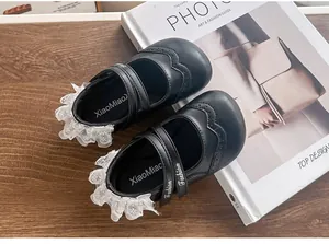 Vue détaillée de chaussures de princesse noires pour filles avec de la dentelle blanche