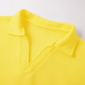 Detalle de primer plano de una sudadera amarilla para hombre con diseño de cuello en V tipo polo.