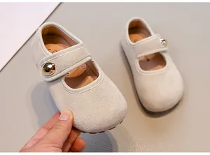 Détail de chaussures de marche Mary Jane en daim beige pour fille avec boucle dorée