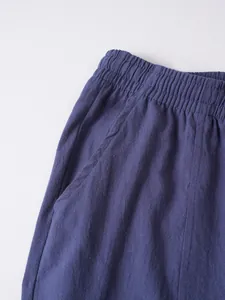 Detailed view of elastic waist and side pocket on men's navy cotton linen casual trousers