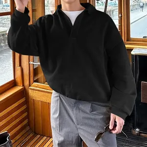 Detalle de sudadera tipo polo negra de manga larga con cuello en V clásica para hombre