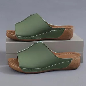 Vista lateral de sandalias de cuña verdes para mujer con detalles de costuras blancas