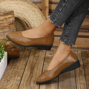 Detailed view of stylish brown stone pattern wedge pumps paired with frayed black denim