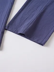 Close-up of the leg cuff and breathable fabric texture of blue cotton linen trousers.