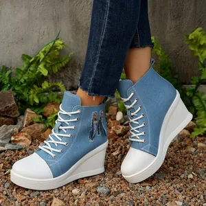 Detailansicht der blauen Denim-Sneakers mit Keilabsatz, weißen Schnürsenkeln und Reißverschluss