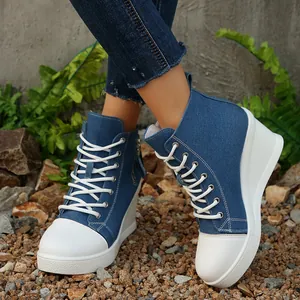 Detailansicht der Damen-Keil-Sneakers aus Denim mit weißem Schnürdesign im Freien