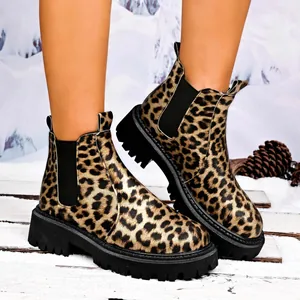 Detail of stylish leopard print platform Chelsea boots on a snowy winter background