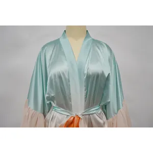 Détail du cache-maillot en satin bicolore soyeux avec une ceinture à nouer orange vif élégante