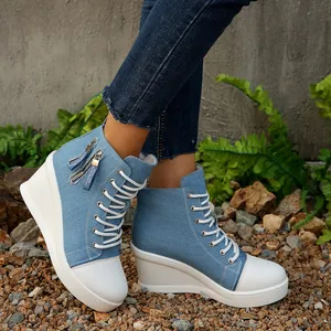 Seitenansicht von hellblauen Denim-Wedge-Sneakern mit weißer dicker Plateausohle.