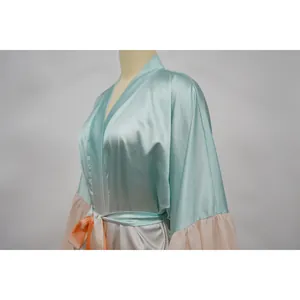 Détail d'un cache-maillot de bain en satin vert menthe avec manches à volants roses.