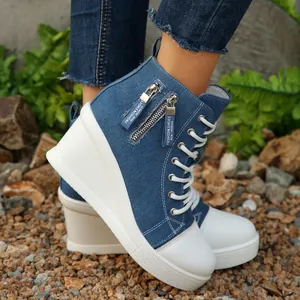 Detail der blauen Denim-Sneakers mit Keilabsatz, weißer Sohle und Reißverschluss