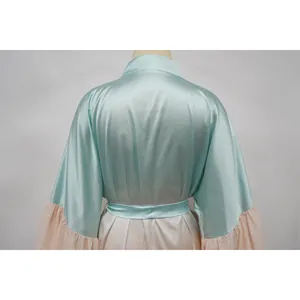 Vue arrière d'un élégant cache-maillot en satin avec contraste bleu clair et pêche