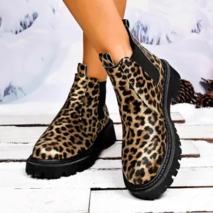 Women's leopard print Chelsea boots with chunky black lug soles in snowy winter scene.