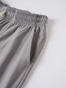 Close-up of men's grey cotton-linen casual pants with elastic waist and side pocket