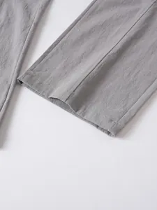 Detailed close-up of grey men's cotton linen trousers showing leg opening texture