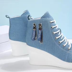 Detail von High-Top-Keil-Sneakers aus Denim mit Reißverschlüssen und weißen Schnürsenkeln.