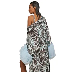 Détail d'un cardigan de plage avec imprimé tourbillon bleu et manches bouffantes voilées